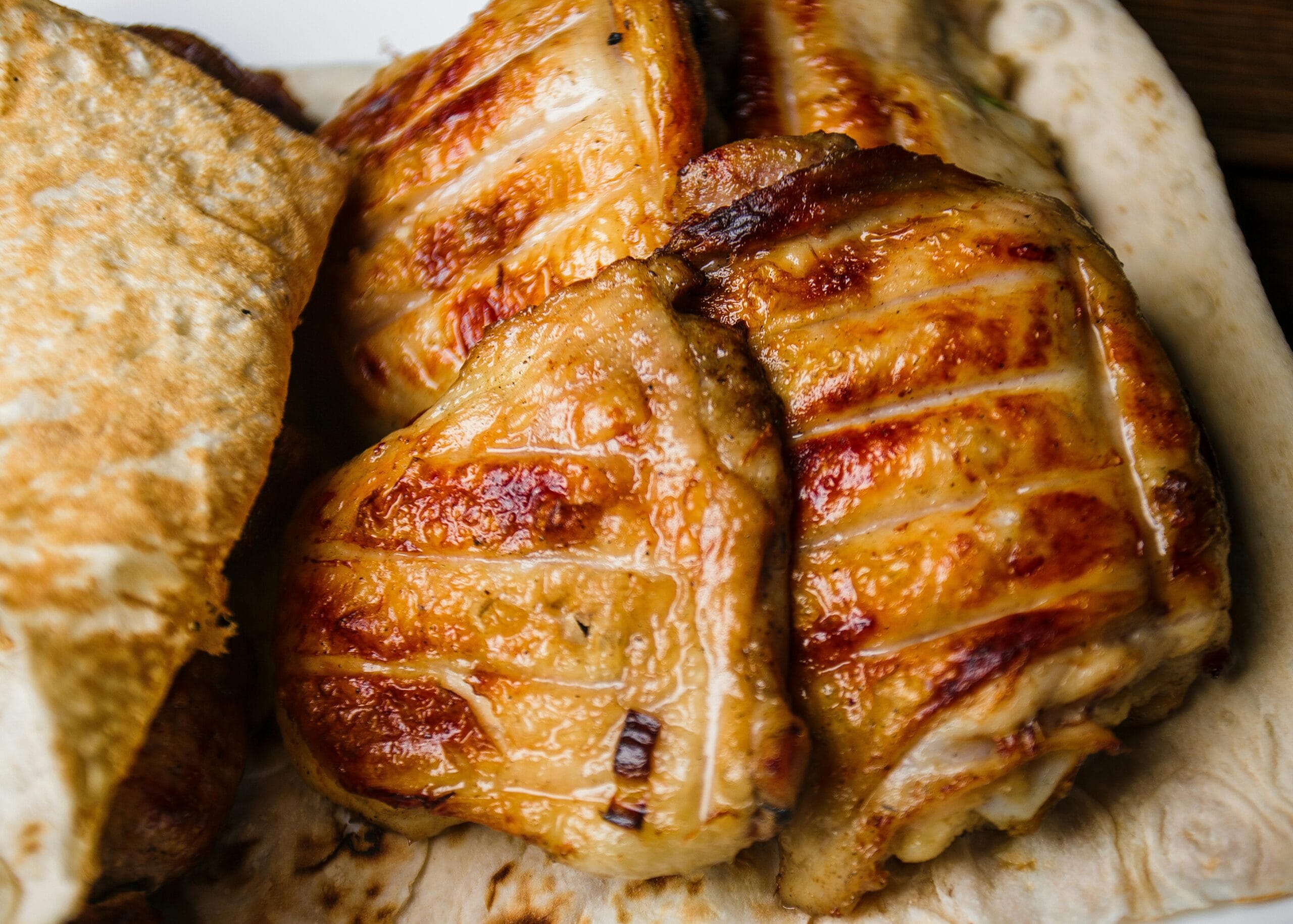 Golden-brown grilled chicken on flatbread for a delicious meal.